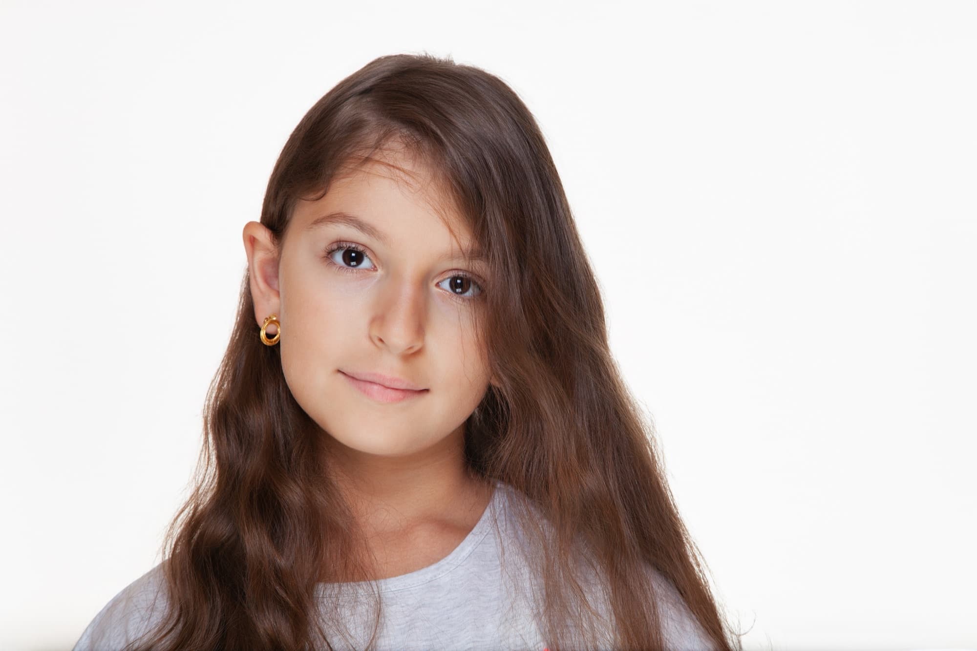 Portrait of a young girl with long brown hair on a white background